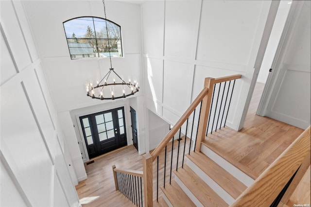 foyer entrance with light hardwood / wood-style floors and an inviting chandelier