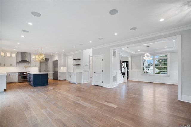 unfurnished living room with light hardwood / wood-style floors and crown molding