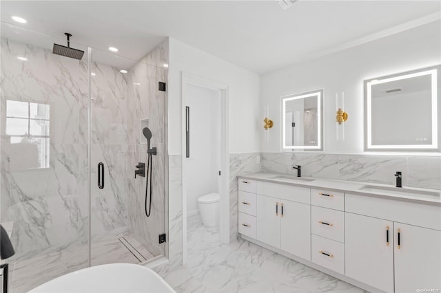 bathroom with vanity, toilet, and a shower with door