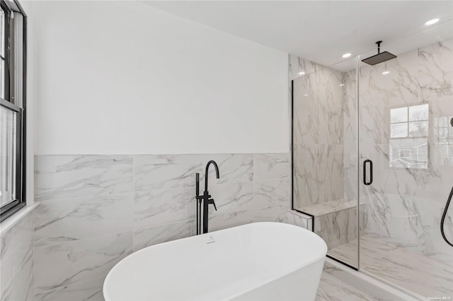 bathroom featuring separate shower and tub and tile walls