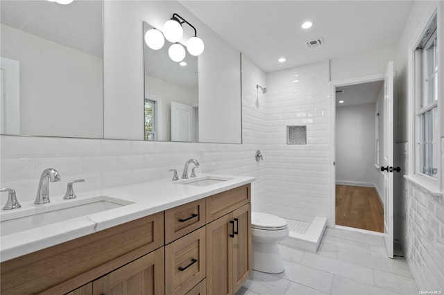 bathroom with tasteful backsplash, tile patterned flooring, a shower, toilet, and vanity