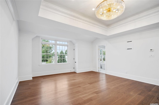 unfurnished room featuring hardwood / wood-style flooring, ornamental molding, a tray ceiling, and a chandelier