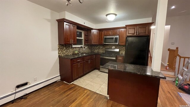 kitchen featuring sink, baseboard heating, tasteful backsplash, light hardwood / wood-style flooring, and appliances with stainless steel finishes