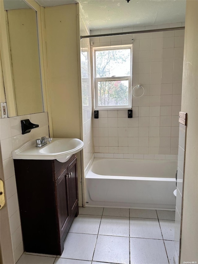 bathroom featuring tile patterned flooring, vanity, and tiled shower / bath combo