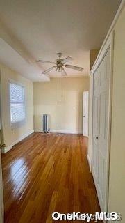 interior space featuring hardwood / wood-style flooring, radiator, and ceiling fan