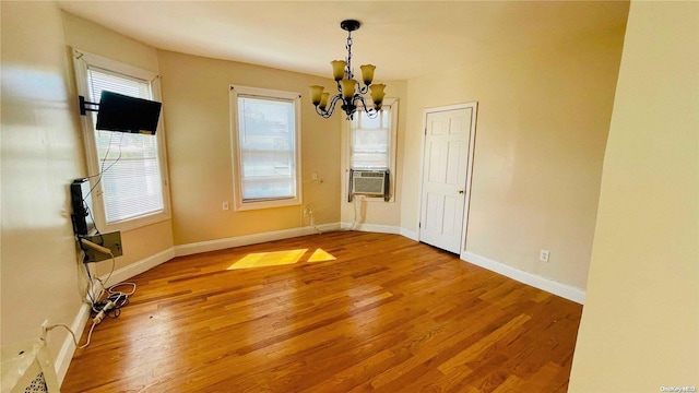 unfurnished dining area with a chandelier and wood-type flooring