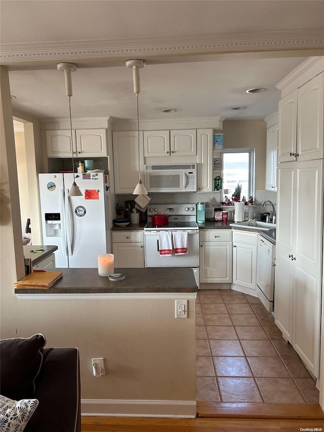 kitchen with kitchen peninsula, white cabinetry, sink, and white appliances