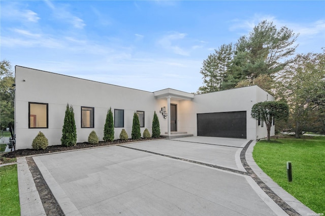 contemporary house featuring a front yard and a garage