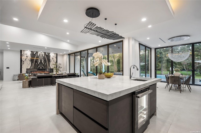 kitchen featuring wine cooler, a large island, sink, and a healthy amount of sunlight