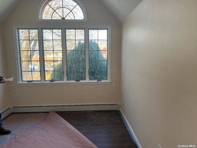 spare room featuring dark hardwood / wood-style flooring, lofted ceiling, and a baseboard heating unit