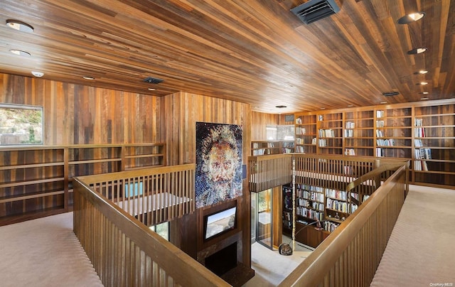 hallway featuring light carpet and wooden ceiling