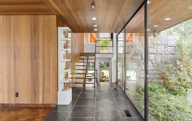 interior space featuring wooden ceiling and wooden walls