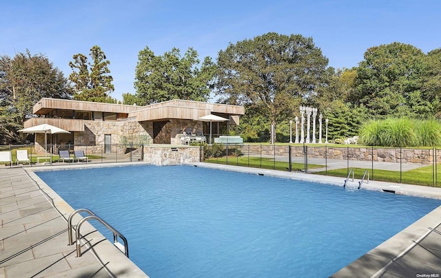 view of swimming pool featuring a patio and exterior kitchen