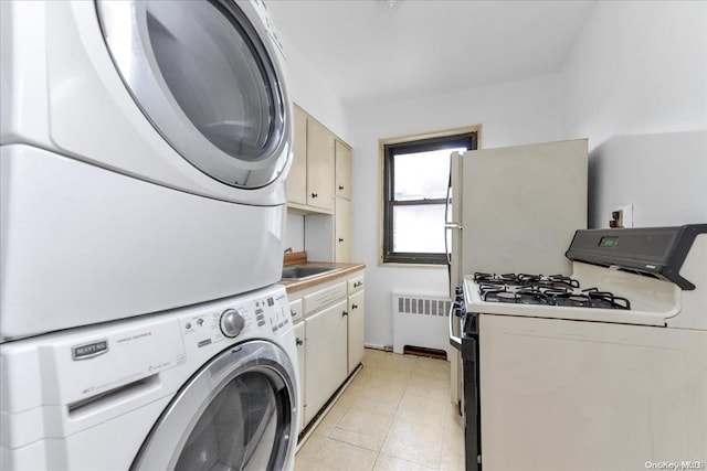 washroom featuring radiator, stacked washer / drying machine, and sink