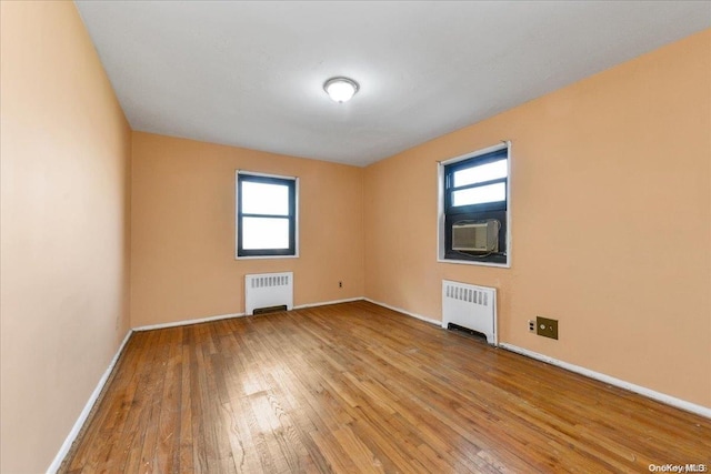 spare room featuring a wealth of natural light, light hardwood / wood-style floors, and radiator