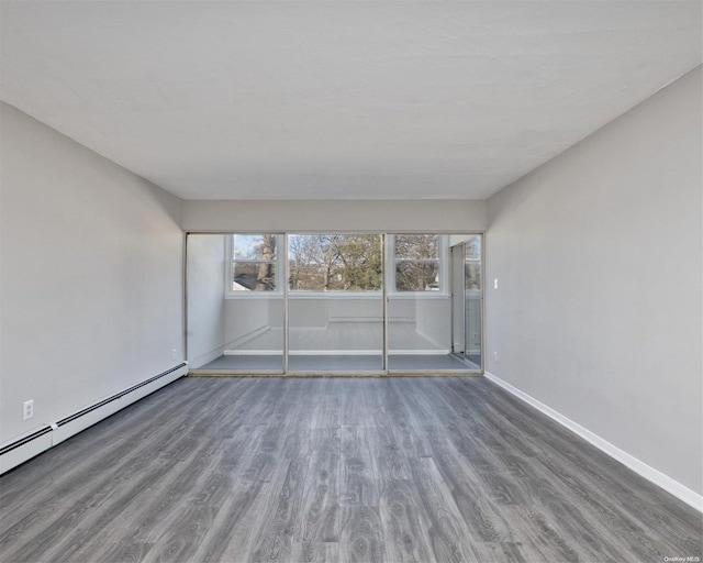 222 Smith St Unit 3C, Freeport, NY 11520 - unfurnished room with wood finished floors, a baseboard radiator, and baseboards