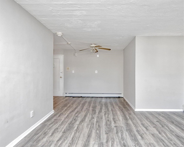 222 Smith St Unit 3C, Freeport, NY 11520 - empty room with a baseboard radiator, a ceiling fan, wood finished floors, and baseboards