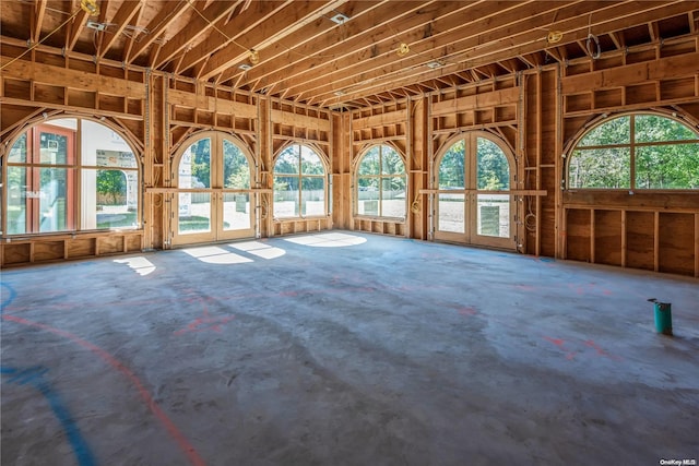 miscellaneous room with concrete flooring, french doors, and a healthy amount of sunlight