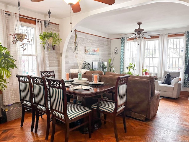 dining room featuring parquet floors, a healthy amount of sunlight, and ceiling fan