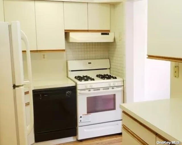 kitchen with white appliances, light hardwood / wood-style flooring, extractor fan, and tasteful backsplash