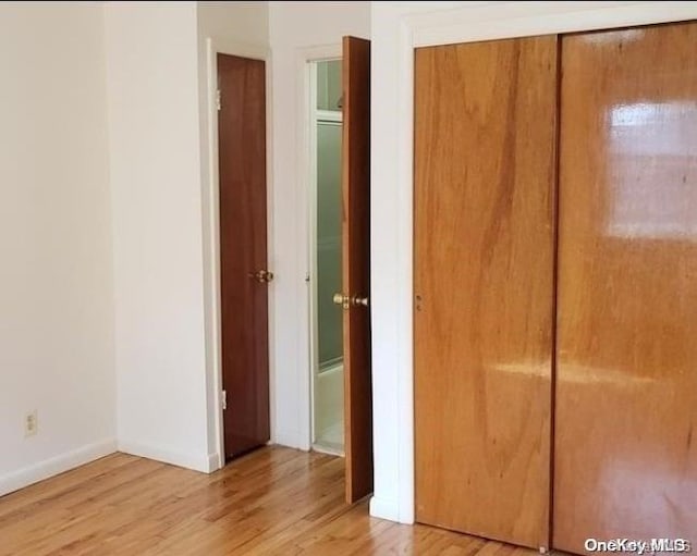 unfurnished bedroom featuring a closet and light hardwood / wood-style flooring