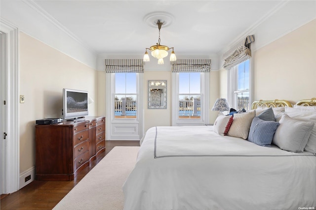 bedroom featuring crown molding, dark wood-type flooring, and an inviting chandelier