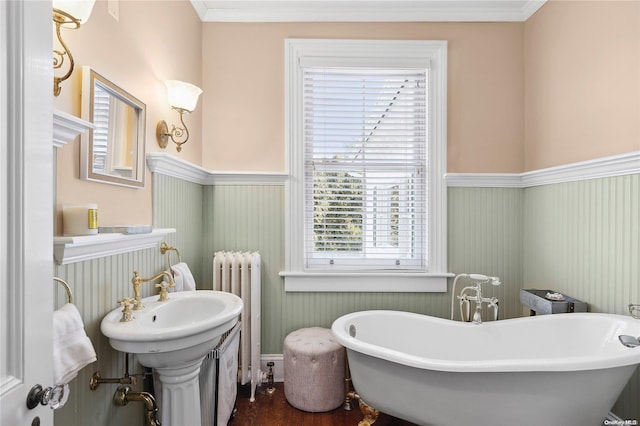 bathroom with hardwood / wood-style floors, a tub to relax in, radiator, and crown molding