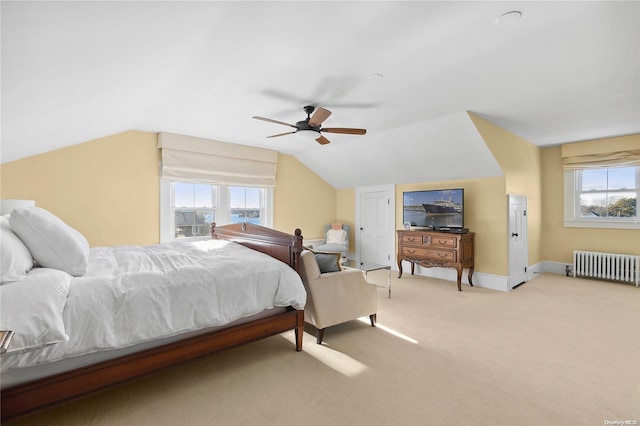 carpeted bedroom featuring multiple windows, ceiling fan, radiator heating unit, and lofted ceiling