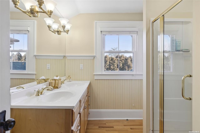 bathroom with wood-type flooring, vaulted ceiling, plenty of natural light, and a notable chandelier