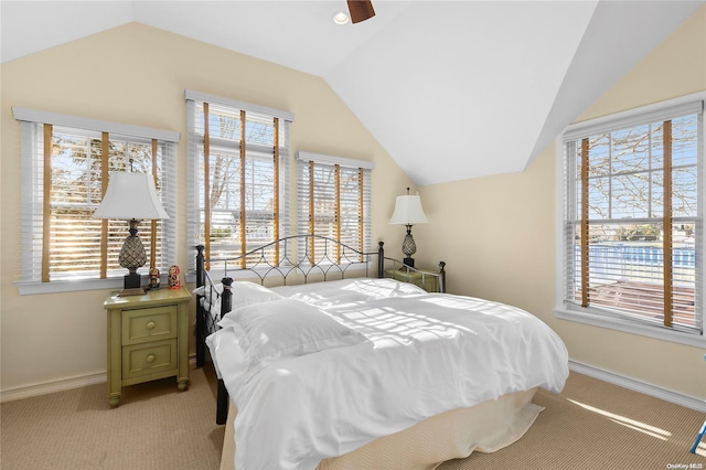 carpeted bedroom featuring multiple windows, ceiling fan, and vaulted ceiling