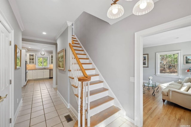 stairs with tile patterned flooring, ornamental molding, and sink