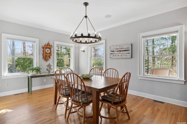 dining area with light hardwood / wood-style flooring, plenty of natural light, and ornamental molding