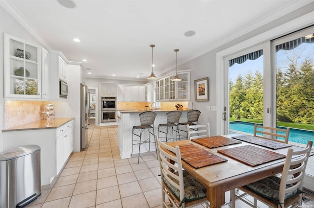 tiled dining space with crown molding and sink