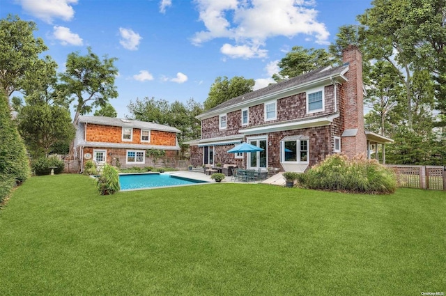 back of property with a lawn and a patio area