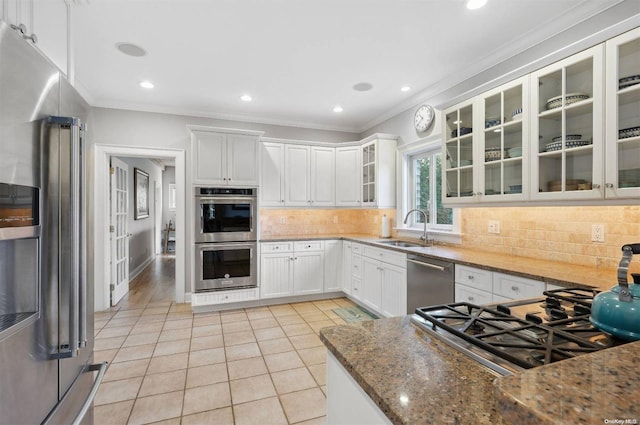 kitchen featuring white cabinetry, sink, appliances with stainless steel finishes, and dark stone counters