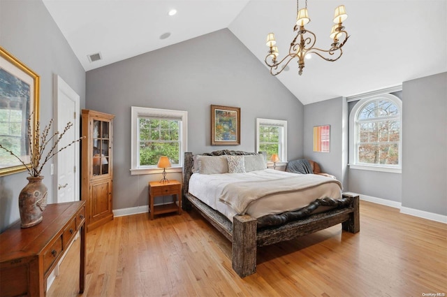 bedroom featuring a notable chandelier, light hardwood / wood-style floors, and high vaulted ceiling