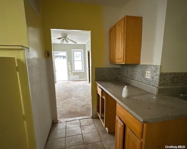 kitchen with light carpet, backsplash, and ceiling fan