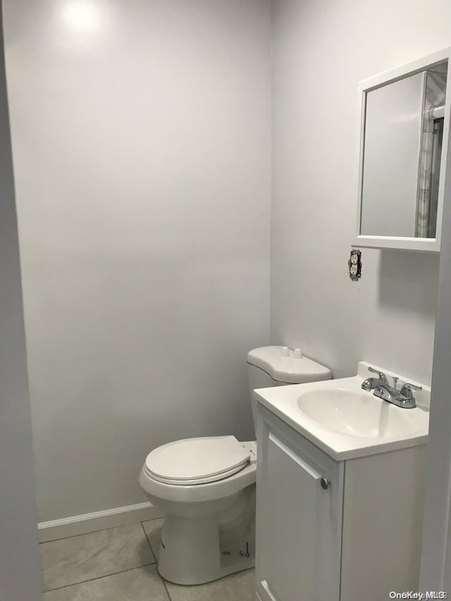 bathroom with tile patterned flooring, vanity, and toilet