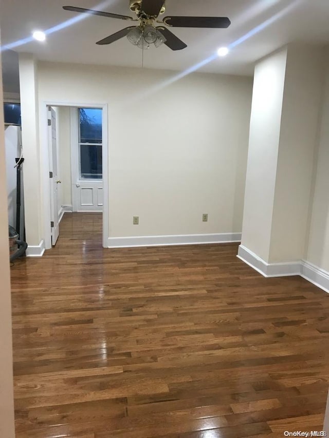 empty room with dark hardwood / wood-style flooring and ceiling fan