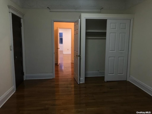 unfurnished bedroom with a closet and dark hardwood / wood-style flooring