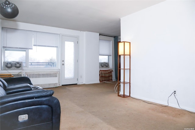 living room with radiator and light colored carpet