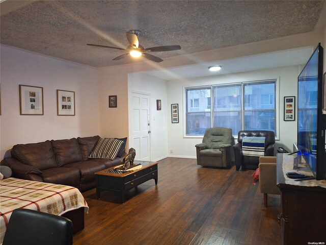 living room featuring ceiling fan, dark hardwood / wood-style flooring, and a textured ceiling