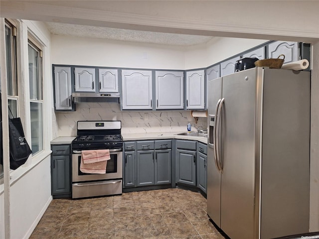 kitchen with backsplash, gray cabinets, sink, and stainless steel appliances