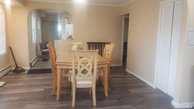 dining space with dark hardwood / wood-style flooring, a baseboard heating unit, and ornamental molding