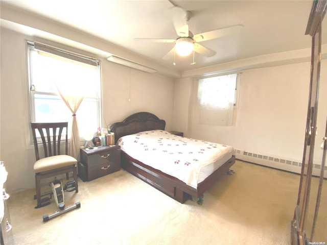 bedroom with baseboard heating, multiple windows, and carpet flooring