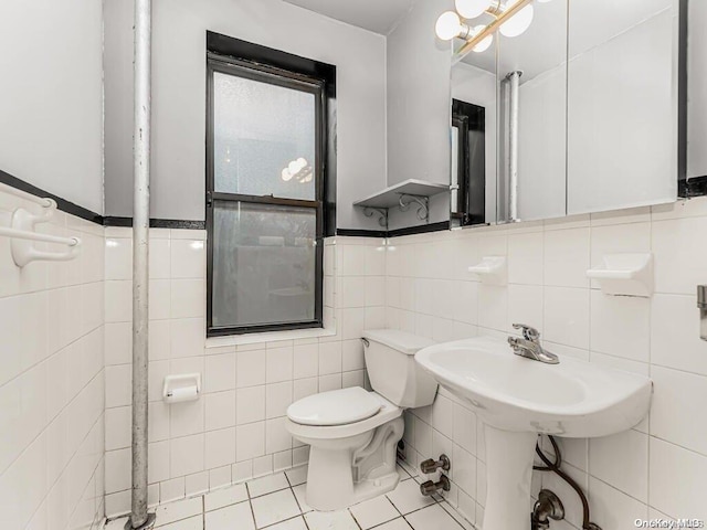 bathroom featuring tile patterned flooring, toilet, and tile walls