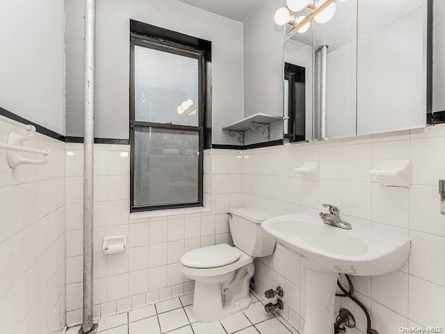 41 Convent Ave Unit 5N, New York Manhattan, NY 10027 - bathroom with tile walls, toilet, tile patterned floors, and a wainscoted wall