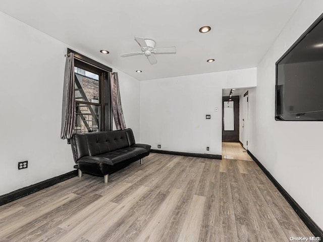 living area featuring light hardwood / wood-style flooring and ceiling fan