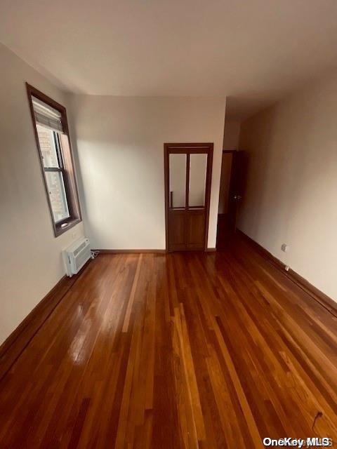 spare room featuring dark hardwood / wood-style floors and a wall mounted AC