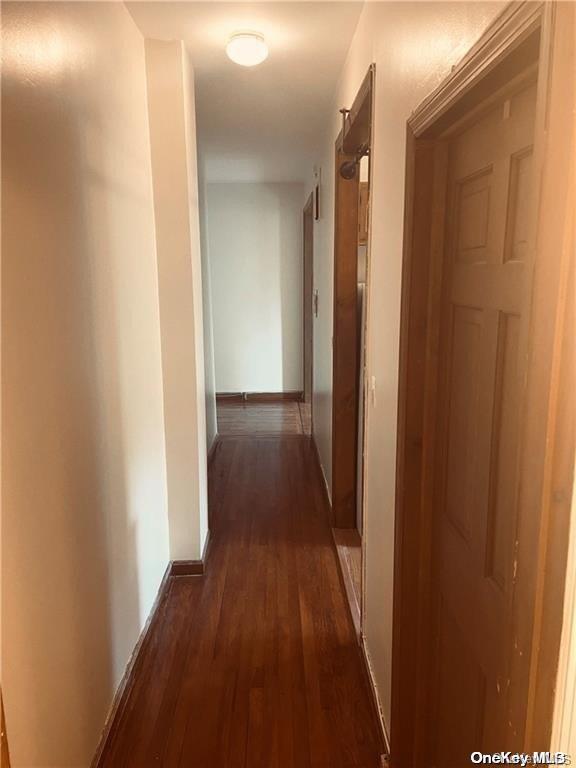 hallway with dark hardwood / wood-style flooring